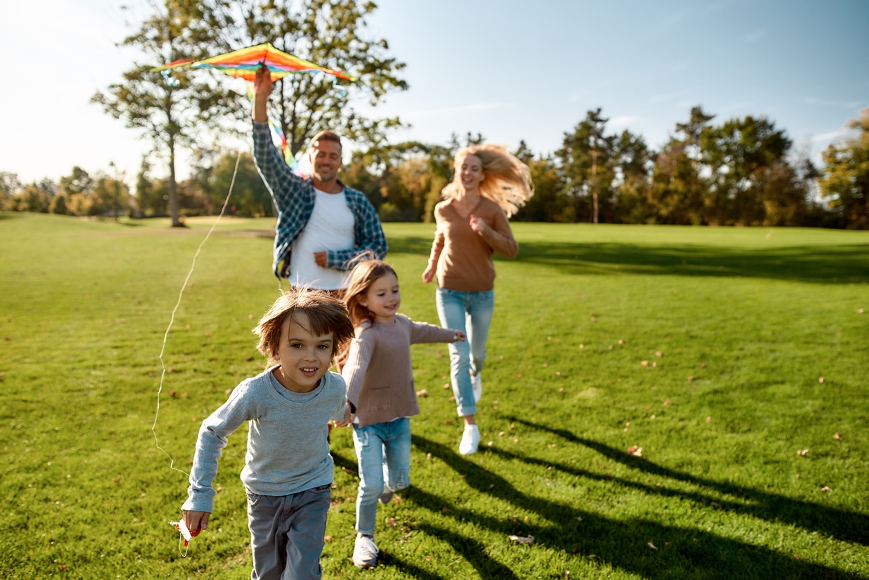 Family running and flying a kite
